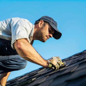 Professional roofer inspecting a residential roof, emphasizing affordable roof repair services