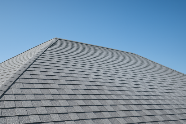 A rooftop with solar reflective shingles under a clear blue sky, highlighting energy-efficient design