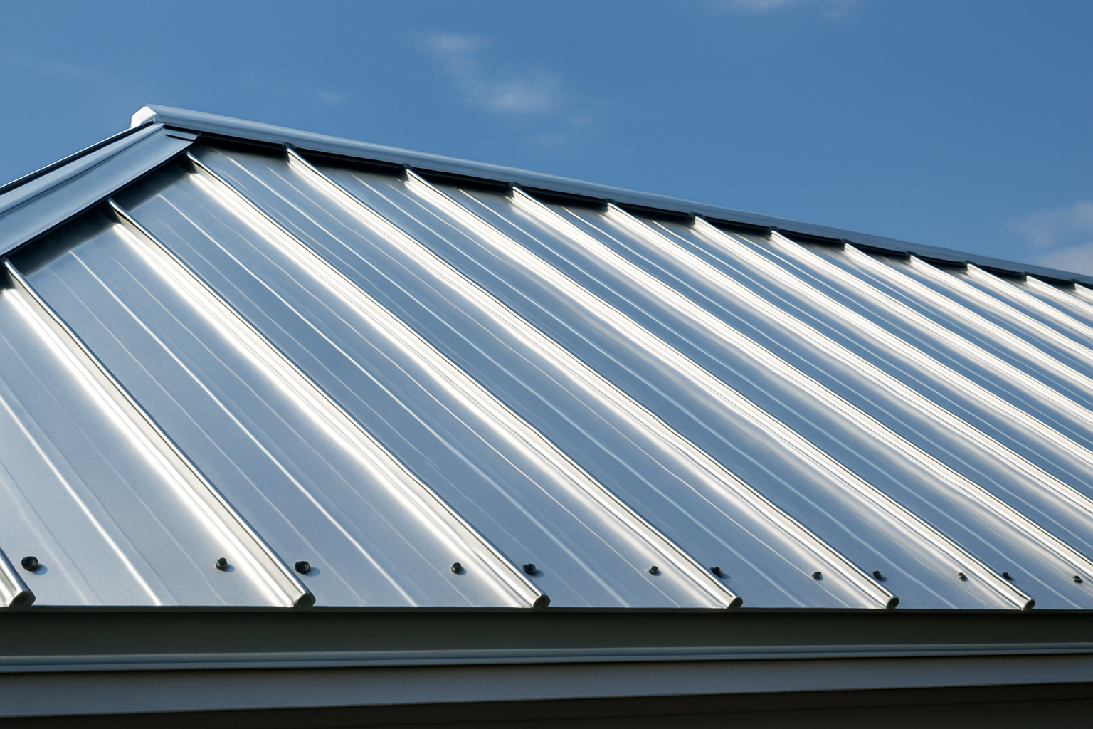 A close-up of a newly installed metal roof with a gleaming silver finish, highlighting its reflective properties.